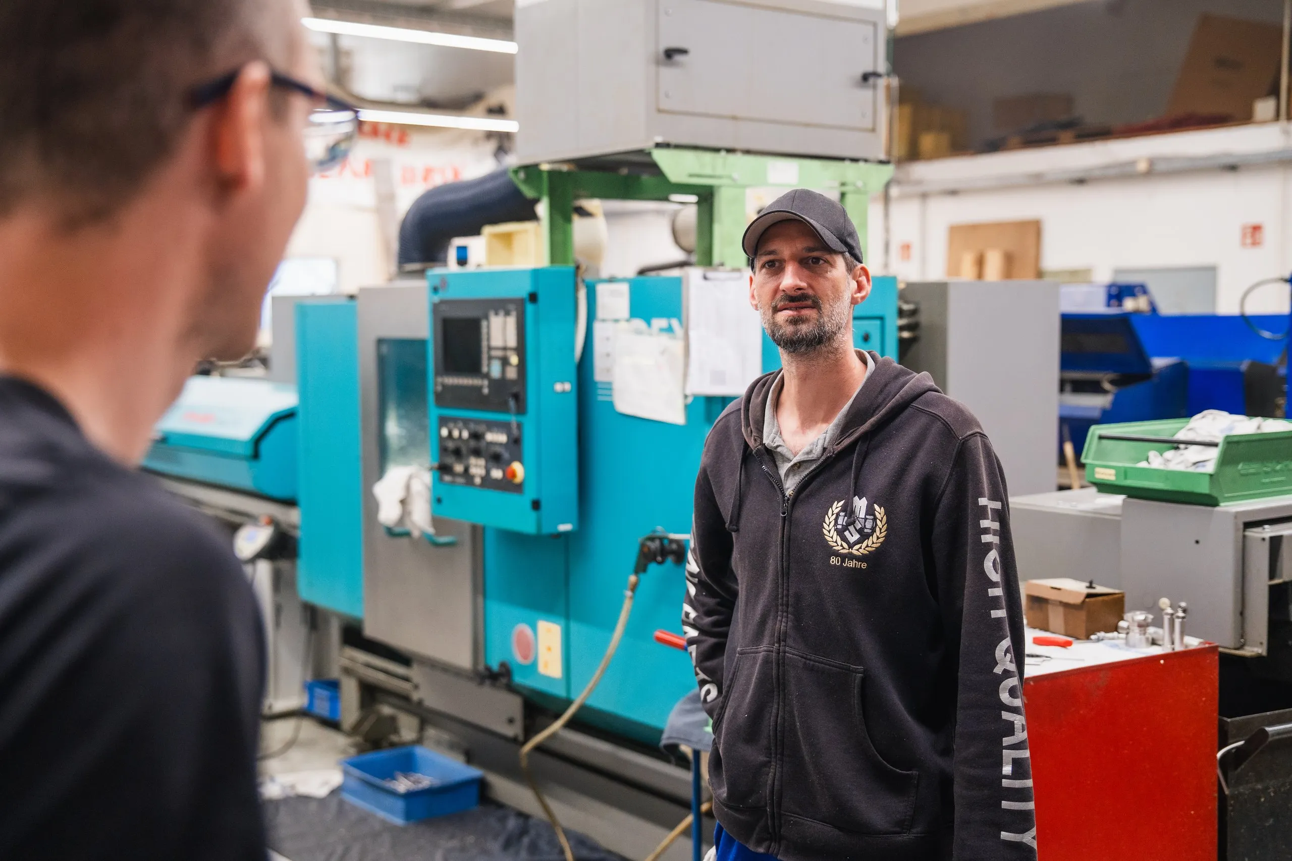 Employees in conversation in the CNC production area